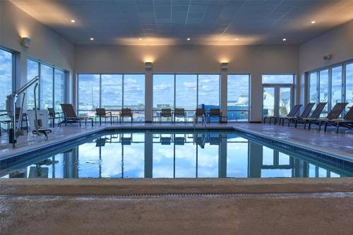 a large swimming pool with chairs and tables in a building at Hyatt Place Ocean City Oceanfront in Ocean City