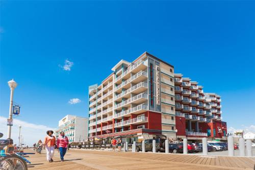 two people walking on a boardwalk in front of a building at Hyatt Place Ocean City Oceanfront in Ocean City