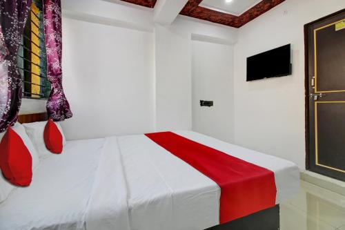 a bedroom with a white bed with a red blanket at Hotel O Bhekrai Nagar Bus Terminal Formerly Silver Star in Phūrsungi