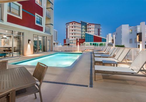 a swimming pool with lounge chairs and a row of apartments at Hyatt Place Ocean City Oceanfront in Ocean City