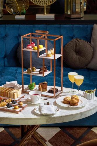 a table with different types of pastries and wine glasses at Waldorf Astoria Dubai International Financial Centre in Dubai