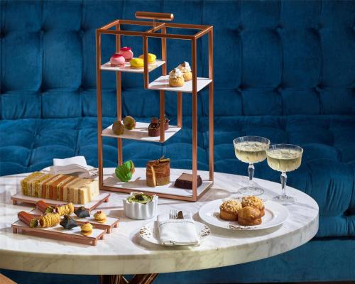a table with plates of food and glasses of wine at Waldorf Astoria Dubai International Financial Centre in Dubai