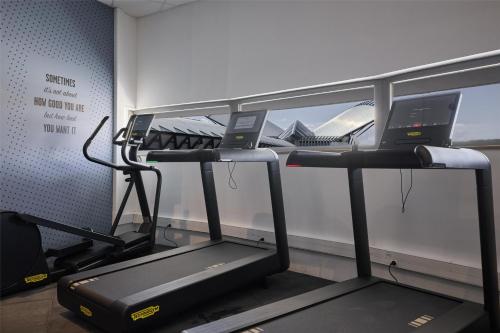 a gym with a treadmill and a laptop on it at Hampton By Hilton Lyon Airport in Colombier-Saugnieu