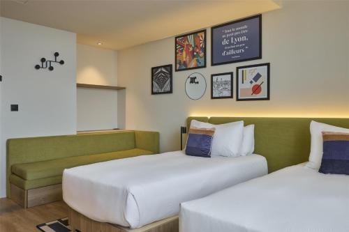 a hotel room with two beds and a sign on the wall at Hampton By Hilton Lyon Airport in Colombier-Saugnieu