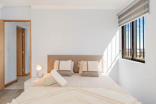 1 dormitorio blanco con 1 cama grande y ventanas en TropiFlic Appartement 2 Chambres avec Rooftop Privé Vue Mer, en Flic en Flac