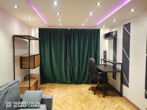 オトフォツクにあるSuper studio w centrum miastaのデスクと緑のカーテンが備わるお部屋
