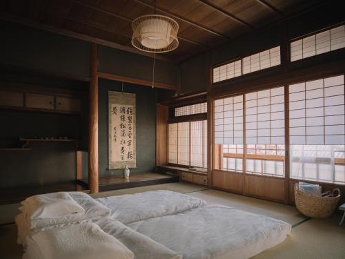 a bedroom with two beds in a room with windows at 自去来 in Hayashima