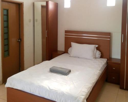 a bedroom with a bed with a pillow on it at House of Felix - Surabaya Guest House in Surabaya