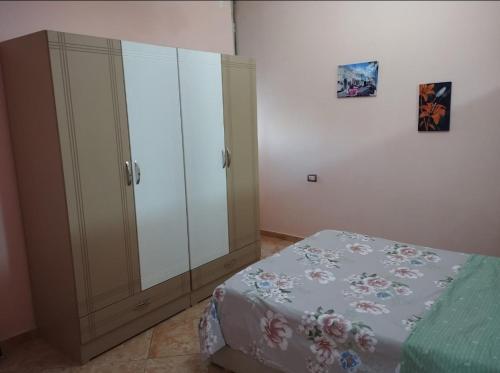 a bedroom with a bed and a large cabinet at Anbel home in Fier
