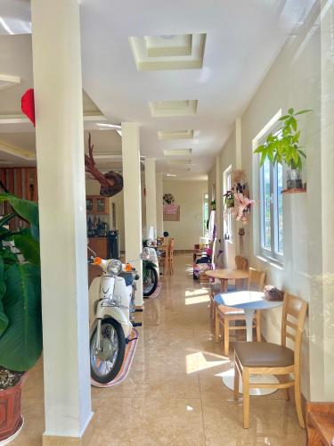 a room with motorcycles parked in a room with tables and chairs at Cloud River Homestay in Da Lat