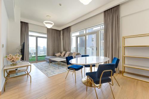 a living room with a table and chairs and a couch at 151 Residence Jumeirah Gardens in Dubai
