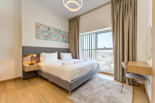 a bedroom with a bed and a large window at 151 Residence Jumeirah Gardens in Dubai