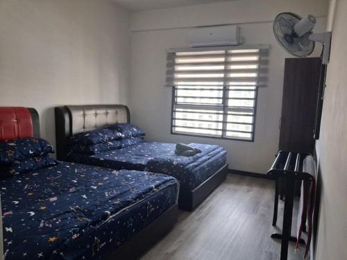 une chambre avec deux lits et une fenêtre dans l'établissement The EH's Homestay Marina View Villa PortDickson, à Port Dickson