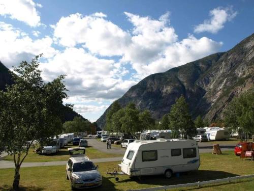 a group of vehicles parked in a parking lot with mountains at 3 person holiday park home, Lærdal in Lærdalsøyri