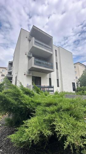 a large white building with grass in front of it at Timisoara Prime Residence - powered by NEO - private parking in Timişoara