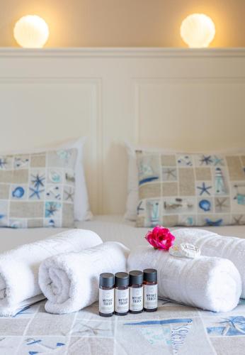 a hotel room with towels and candles on a bed at Mythos Suites Diskos in Léntas