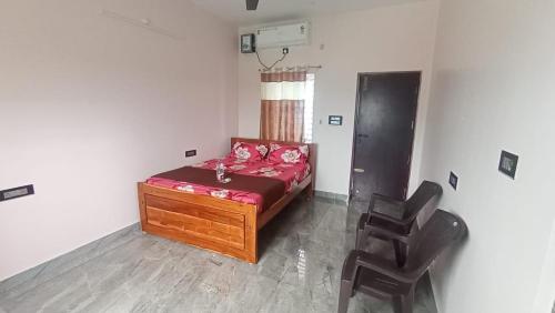 a small bedroom with a bed and two chairs at Muthala Residency in Tiruvannāmalai