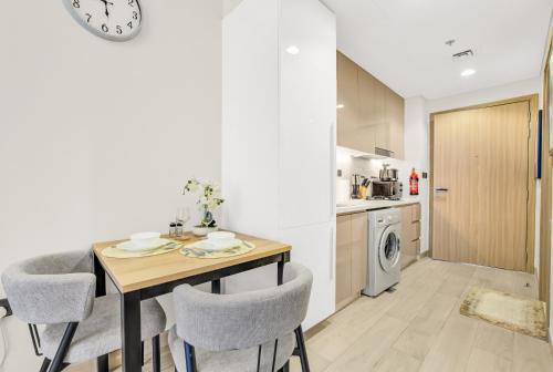 eine Küche und ein Esszimmer mit Tisch und Stühlen in der Unterkunft Elegant Studio with Pool Access & Private Terrace in Dubai