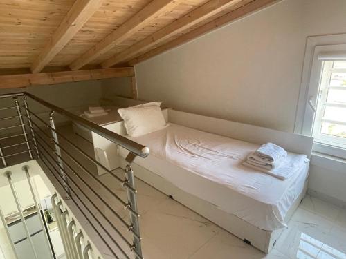 a small bed in a room with a wooden ceiling at Villa Nikiti View in Nikiti