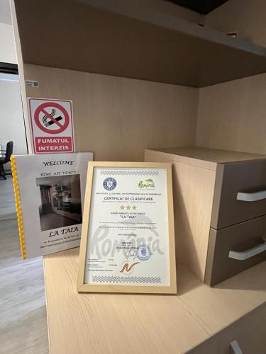 a sign sitting on a counter next to a box at La TAIA! Clasificat 3 Stele! in Piatra Neamţ
