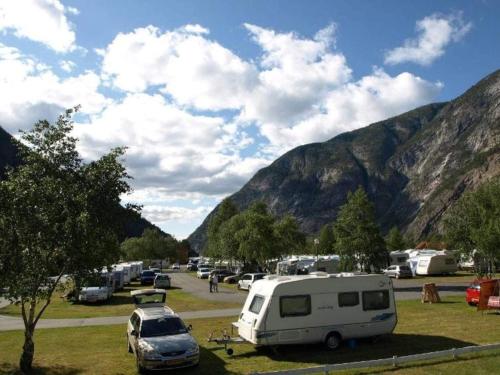 a group of vehicles parked in a parking lot with mountains at 5 person holiday park home in Lærdal in Lærdalsøyri