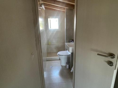a small bathroom with a toilet and a window at Villa Nikiti View in Nikiti