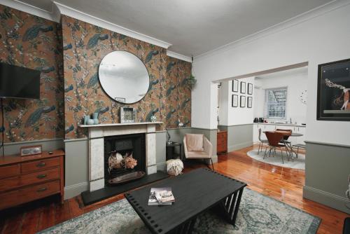 a living room with a fireplace and a mirror at The Pavilion End - Central Paddington Apartment in Sydney