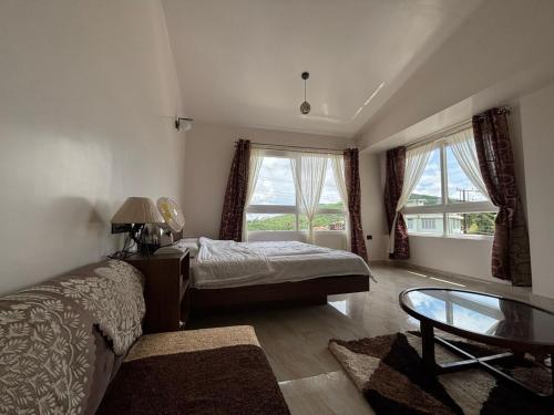 a bedroom with a bed and a glass table at Kerphida B&B in Shillong