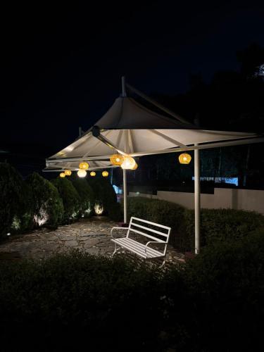a white bench under an umbrella at night at Kerphida B&B in Shillong
