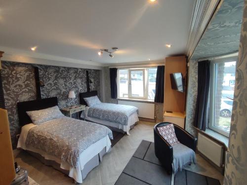 a hotel room with two beds and a chair at Marie's Bed and Breakfast in Coolock