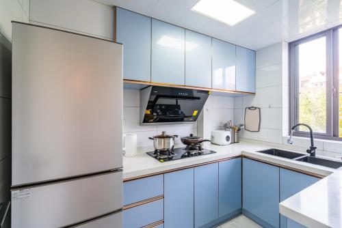 a kitchen with blue cabinets and a sink at Nanjing West Road elevator two-bedroom, three-bed apartment close to the subway in Shanghai