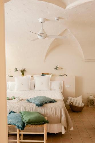 a bedroom with a white bed with a ceiling at Arkhé Hotel Boutique Pals in Pals