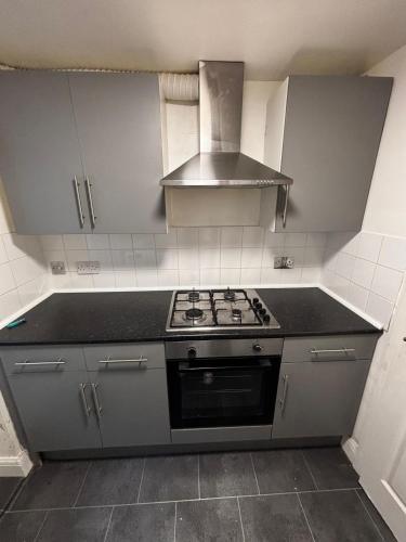 a kitchen with a stove and a stove top oven at Cosy City Hideout in London