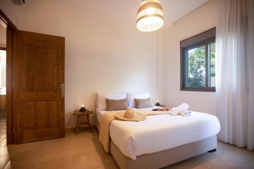a bedroom with a bed with a hat on it at Akl - Chic Apartments & Balconies in Batroun in Batroûn