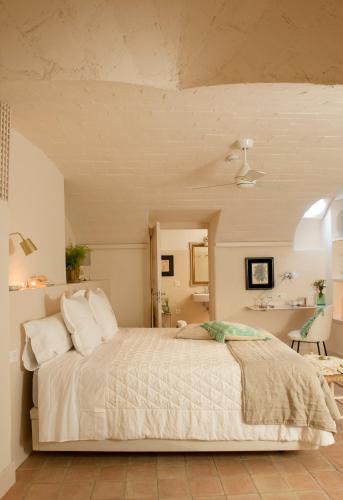 a bedroom with a large bed with white sheets and pillows at Arkhé Hotel Boutique Pals in Pals