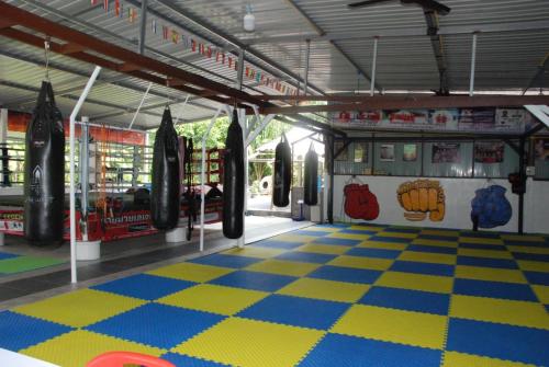 una palestra con sacchi da boxe e pavimento a scacchi di Legend muay thai gym a Ban Nong Chaeng
