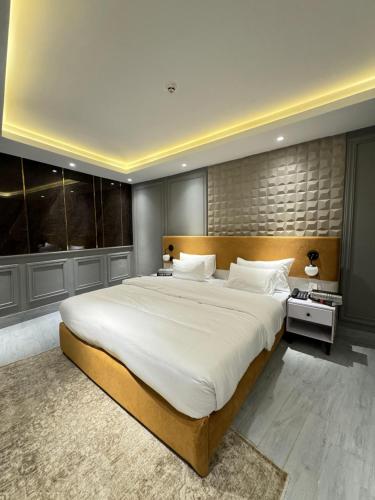 a large bedroom with a large bed with white sheets at The Khushi Hotel And Resorts in Murree