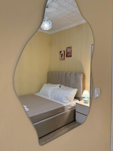 a bedroom with a bed and a mirror at Nanini Apartment in Tbilisi City