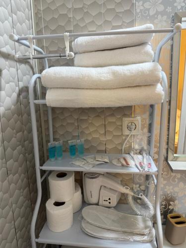 a towel rack with towels and toiletries in a bathroom at Nanini Apartment in Tbilisi City