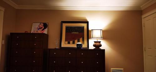 a bedroom with a dresser and a lamp and a picture at Eagle's House, Room #B in Victoria