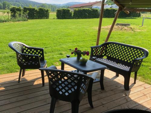 a table and chairs on a deck with an umbrella at Kemp Sluknov- Glamping in Děčín