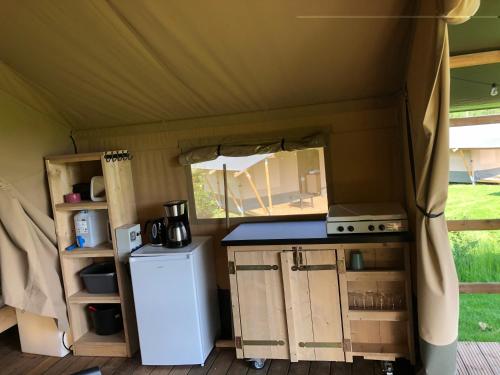 a kitchen with a stove and a refrigerator in a tent at Kemp Sluknov- Glamping in Děčín