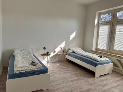 Un dormitorio con dos camas y una ventana. en Arbeiter - Lounge 1, en Salzgitter