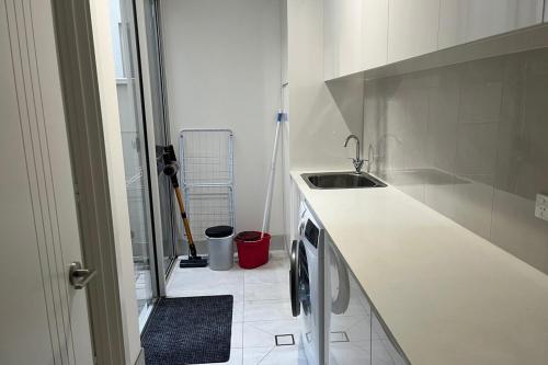 a white kitchen with a sink and a counter at Timeless Tranmere Escape By Host Solutions in Norwood