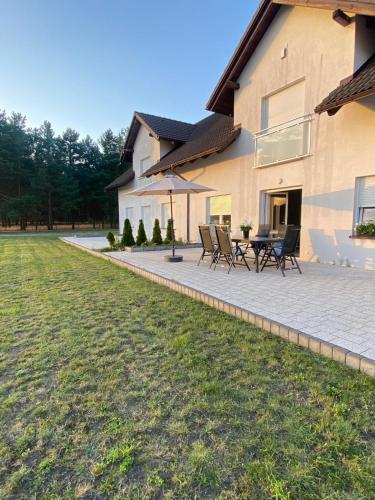 a patio with chairs and a table in front of a house at Lasy Jeziora, Cisza i Spokój, Grzybki i Rybki, Dom 180m2 w Swornegacie nad jeziorem Karsińskim in Swornegacie 