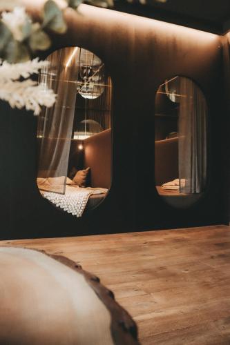 a room with two mirrors and a wooden table at Hüttendorf Schlögelberger in Sankt Margarethen im Lungau