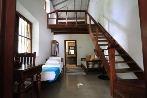 a bedroom with a staircase and a bed in a room at Villa Kobeimalhéna, Matara in Sulutanagoda