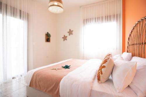 a bedroom with a bed with white sheets and stars on the wall at Akl - Chic Apartments & Balconies in Batroun in Batroûn