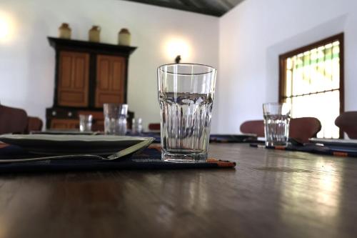 a wooden table with a glass on top of it at Villa Kobeimalhéna, Matara in Sulutanagoda