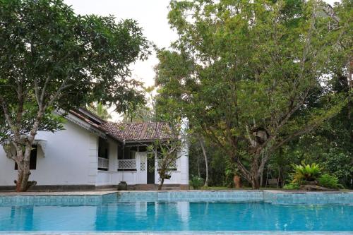 a house with a swimming pool and trees at Villa Kobeimalhéna, Matara in Sulutanagoda
